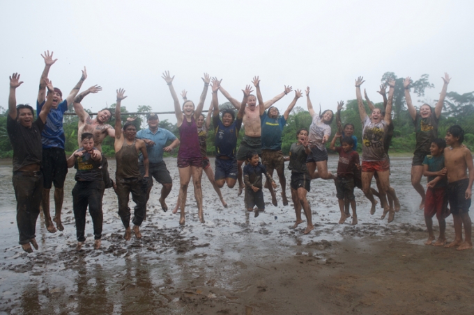 Students having fun in the mud on a rainy day in Ecuador